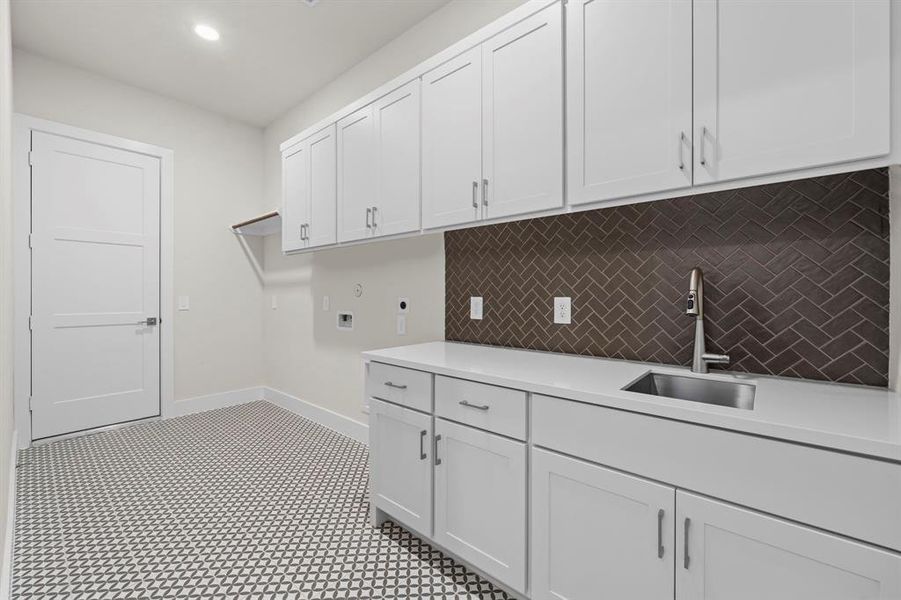 Utility Room with Sink, Storage, Washer and Dryer Connections, and Hanging Bar.