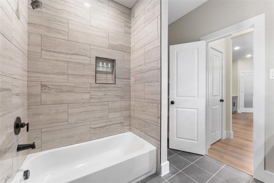 Bathroom with tile patterned flooring and tiled shower / bath