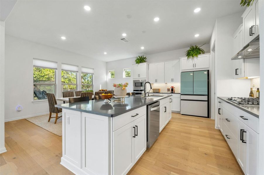 The chic and modern island kitchen opens seamlessly to the living room while still providing a nice separation of spaces.