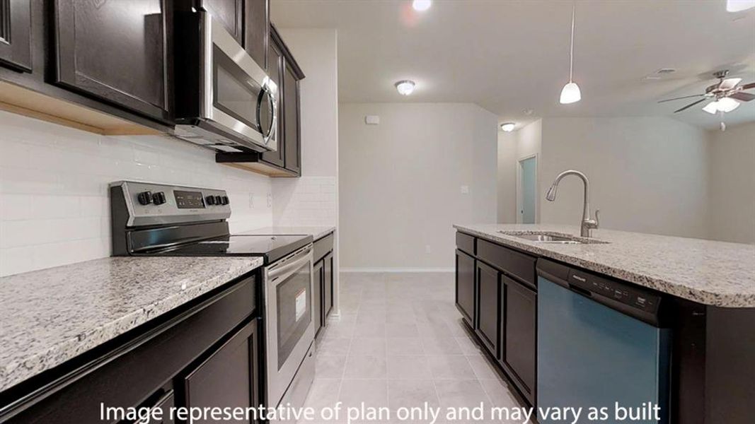 Kitchen with stainless steel appliances, pendant lighting, decorative backsplash, and light stone countertops Kitchen with stainless steel appliances, pendant lighting, decorative backsplash, and light stone countertops