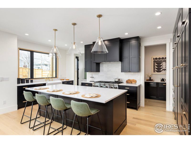 Beautiful chef's kitchen with top-of-the-line built-in appliances, custom-stained white oak cabinetry, farmhouse sink, walk-in pantry, and slab quartzite countertops.