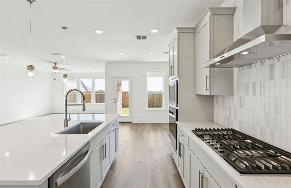 Large island overlooking gathering room and dining areas
