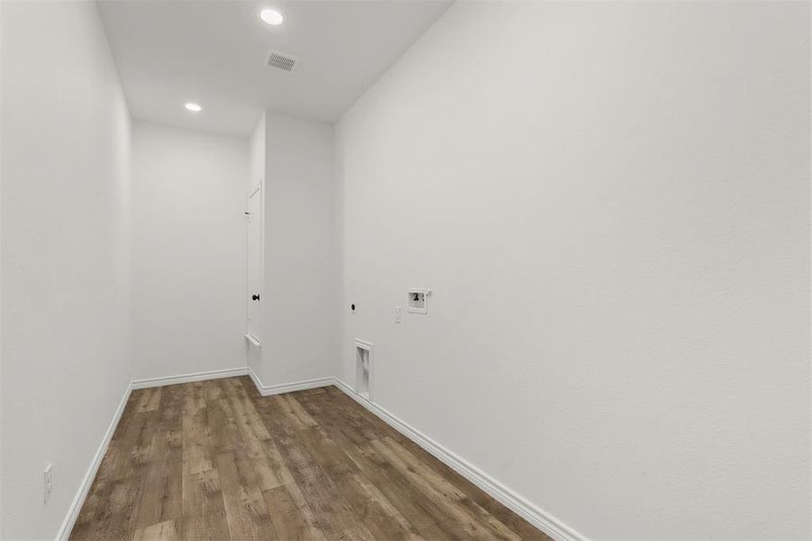 Laundry room with hookup for a washing machine, wood-type flooring, and hookup for an electric dryer