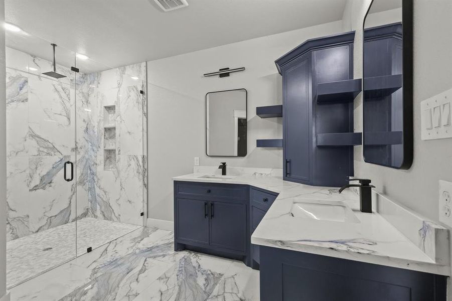 Full bathroom featuring a marble finish shower, marble finish floors, vanity, and baseboards