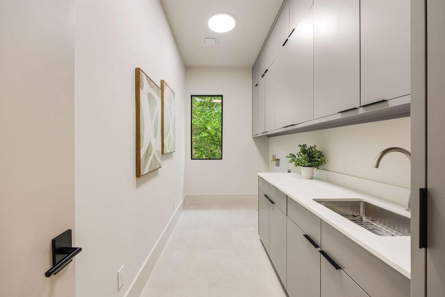 [UTILITY-2ND FLR] Beautifully integrated into the second floor, the oversized utility room offers custom cabinetry, expansive countertop space, and abundant storage, delivering both elegance and exceptional practicality.