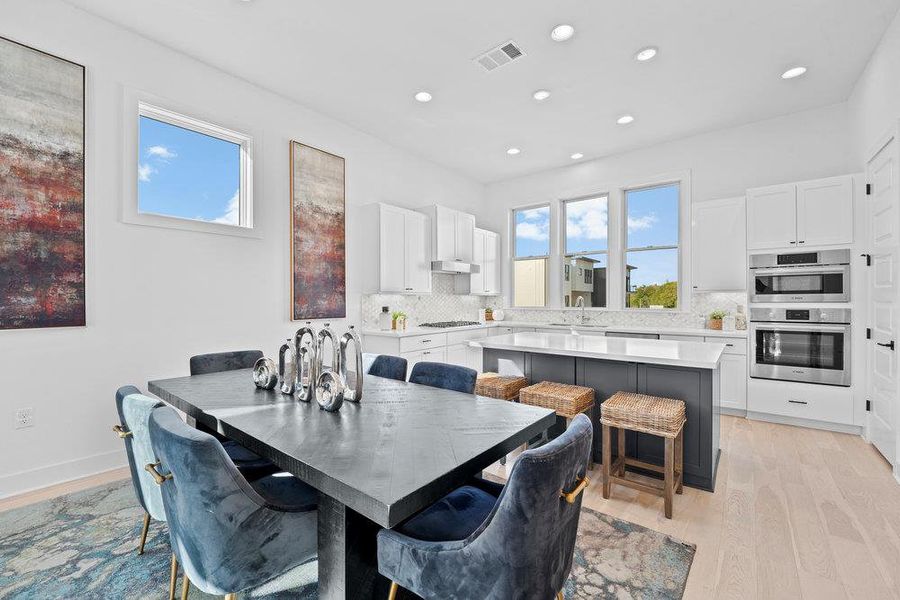 Dining room featuring healthy amount of natural light, recessed lighting, and light wood-type flooring