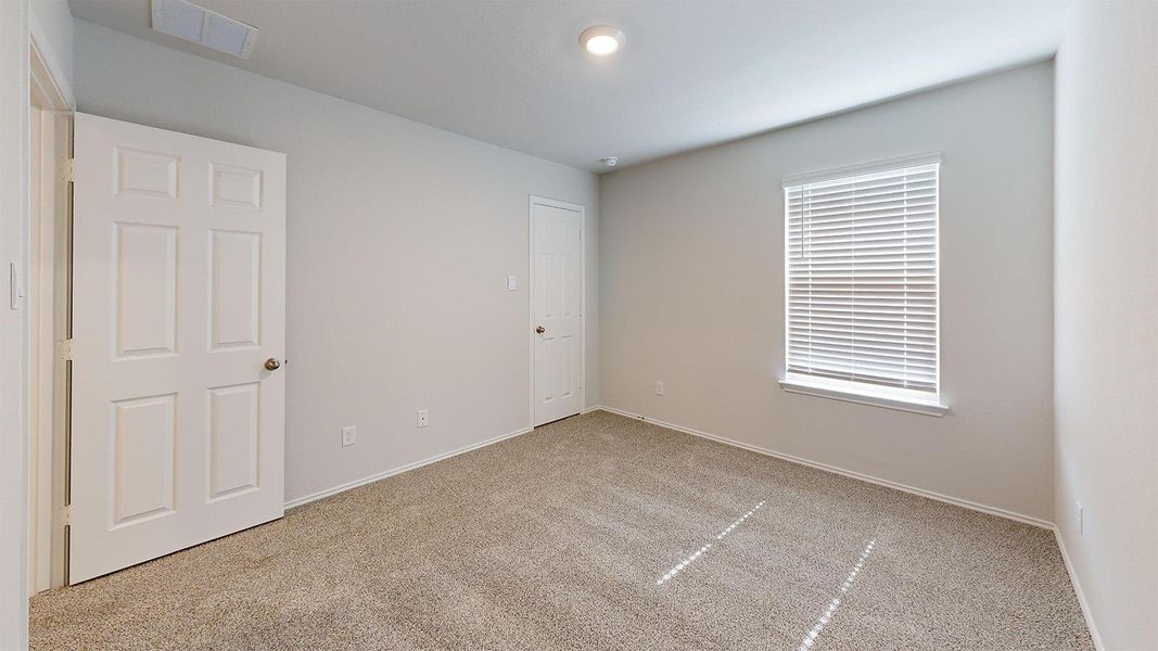 Unfurnished bedroom featuring light colored carpet and baseboards