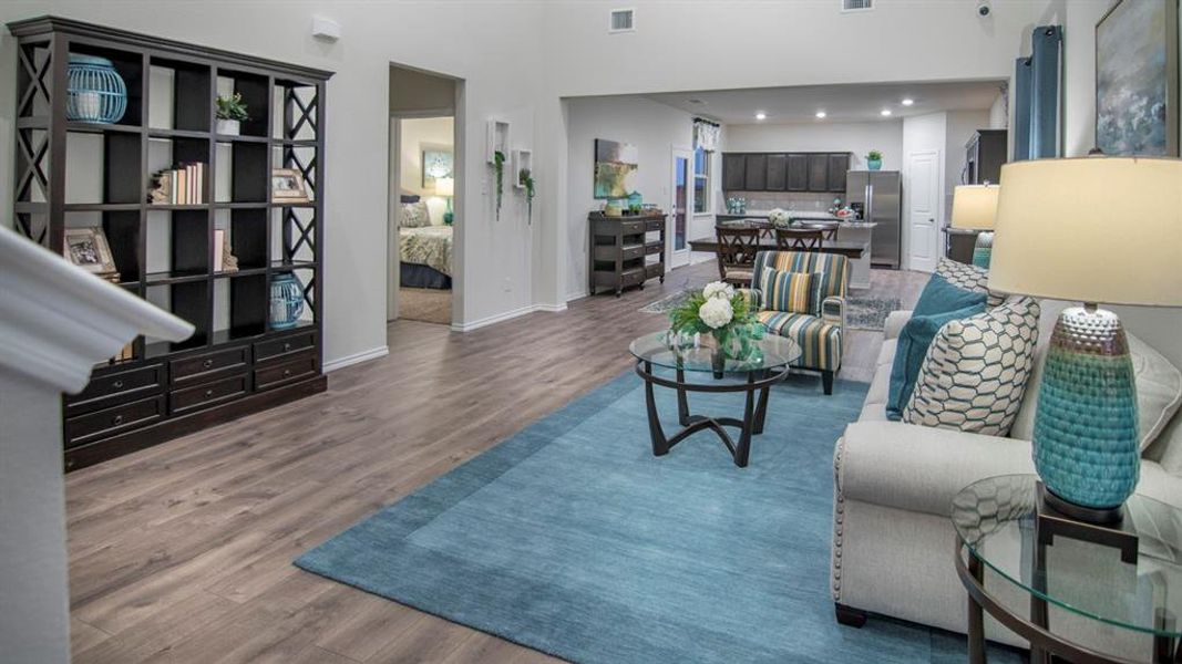 Living room featuring dark wood-style floors, a high ceiling, and recessed lighting