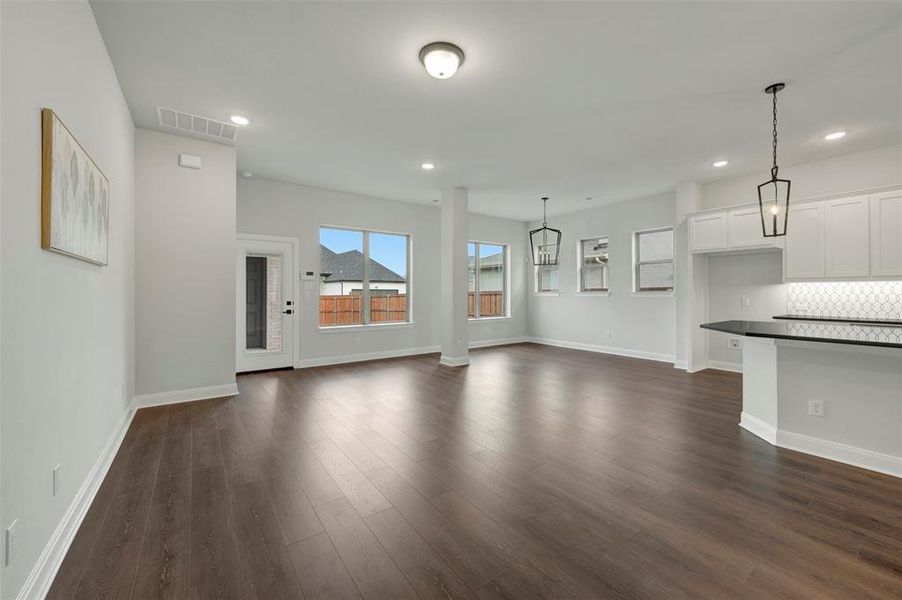 Unfurnished living room featuring dark wood finished floors and recessed lighting