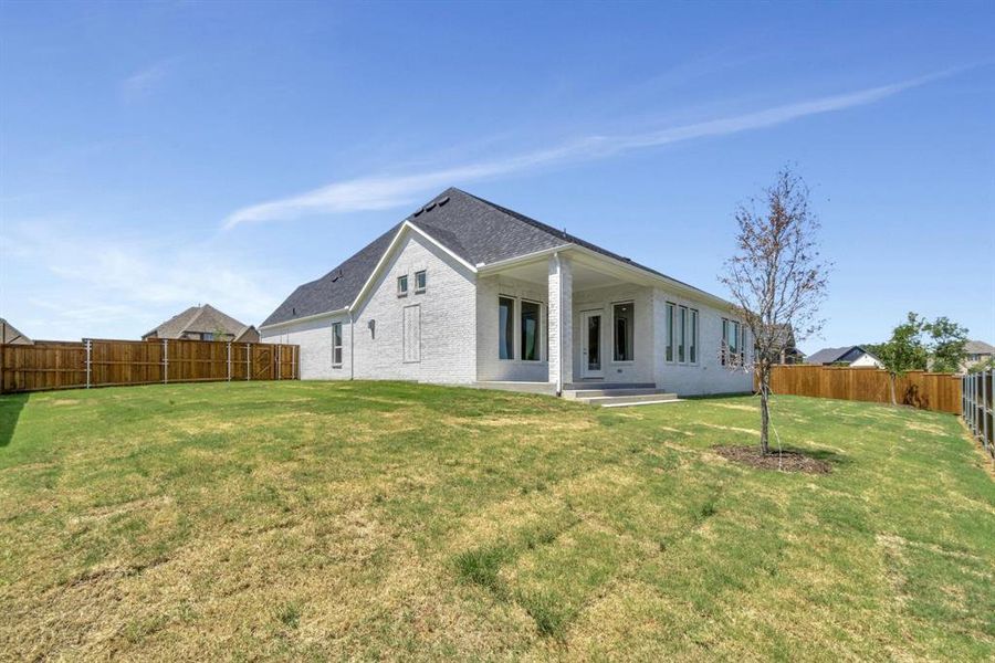 Rear view of property featuring a yard and a patio area