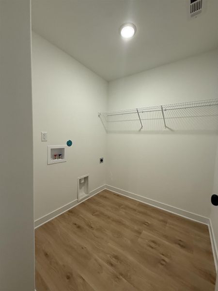 Laundry area featuring wood finished floors, electric dryer hookup, and washer hookup