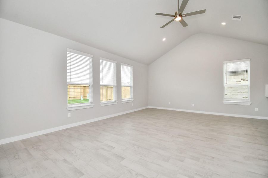 Welcome family and guests to your charming living room! With its high ceilings, recessed lighting, ceiling fan, custom paint, beautiful flooring, and large windows that let in abundant natural light, this room is perfect for gatherings.