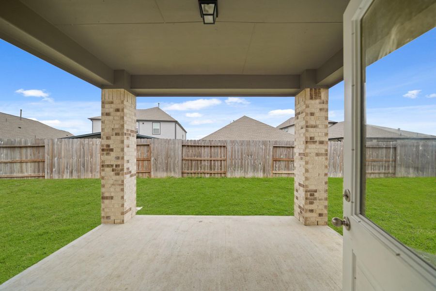 Kick back and relax on the covered backyard patio and enjoy the spacious lawn.