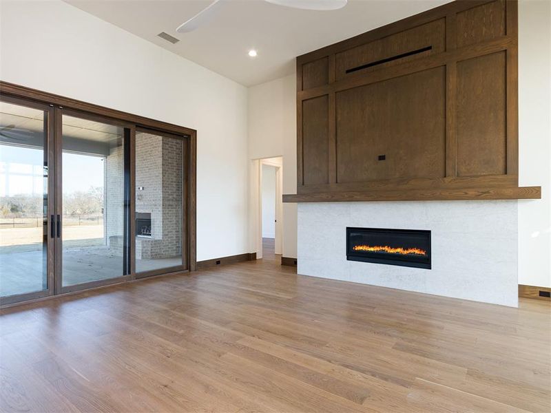 Wood paneling above the 55" linear fireplace in the family room adds an extra decorator touch!