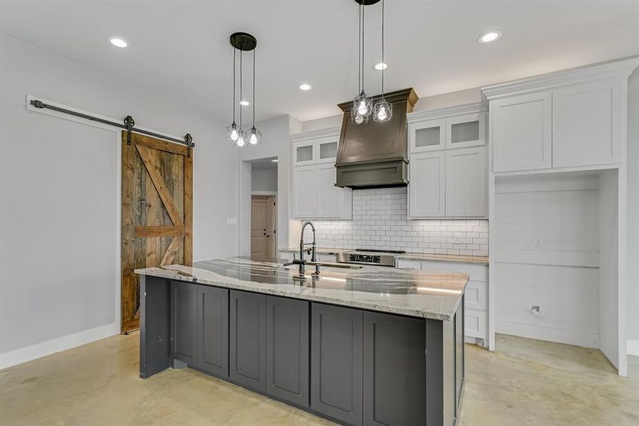 Kitchen with concrete flooring, a sink, backsplash, white cabinets, and baseboards