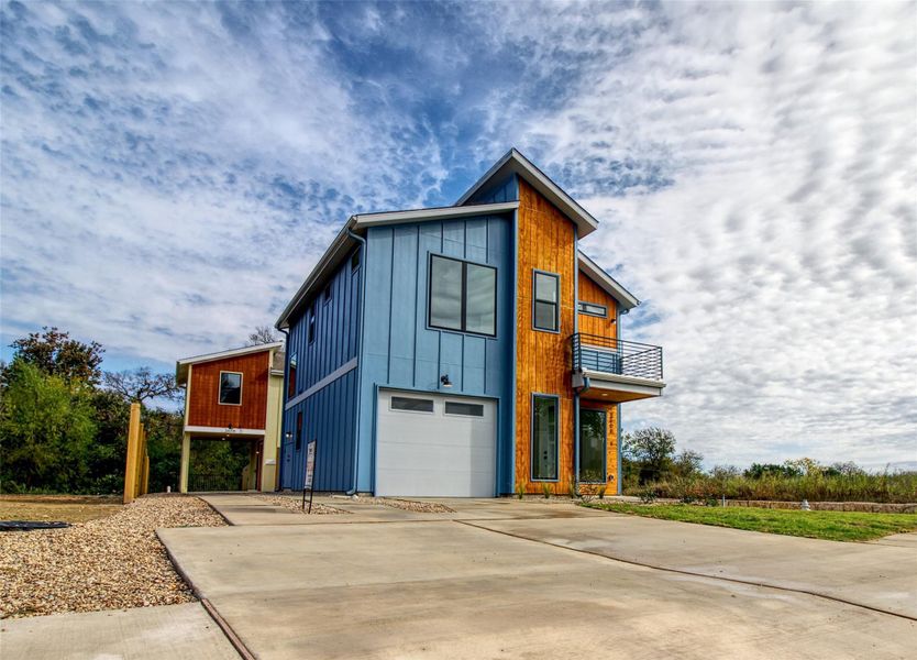 View of front of property with a balcony, concrete driveway, and an attached garage