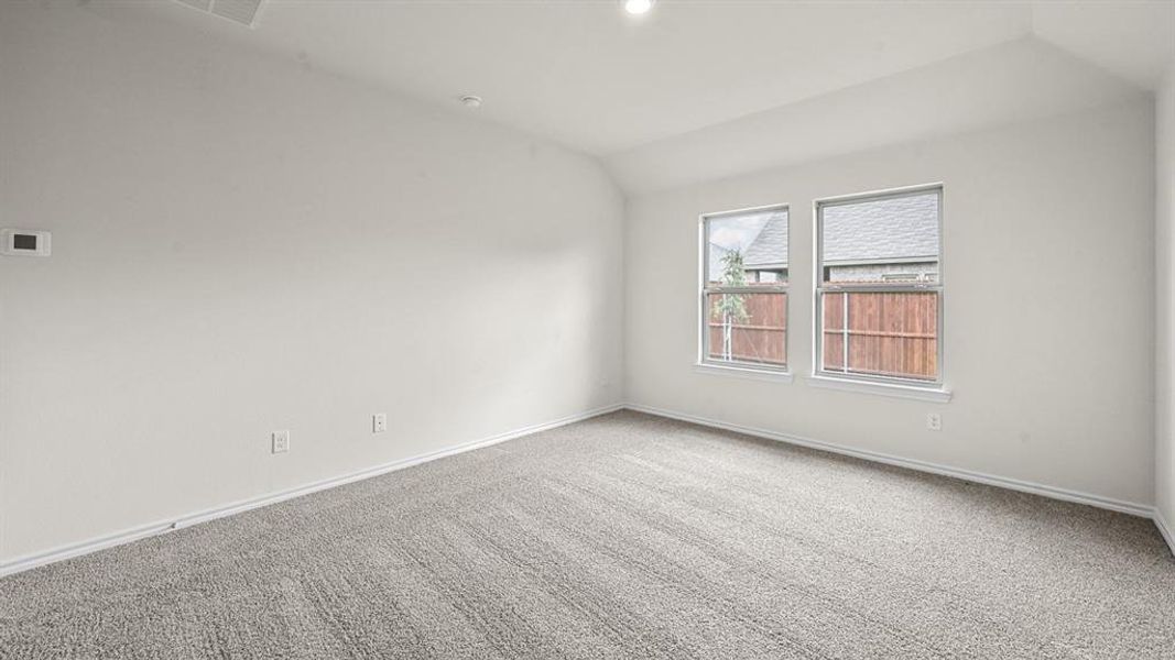 Spare room with lofted ceiling and carpet floors
