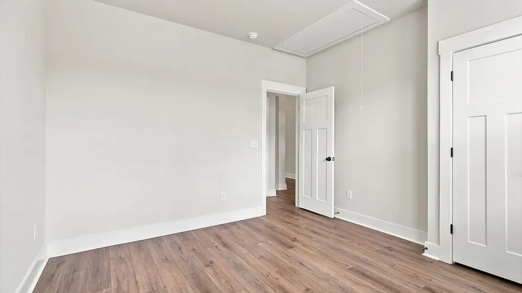 Superior comfort in a secondary bedroom with hardwood floors and an oversized walk-in closet