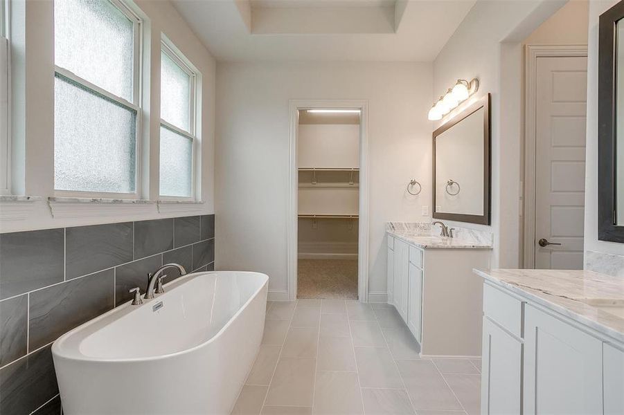 Bathroom with tile patterned flooring, a bathtub, and vanity