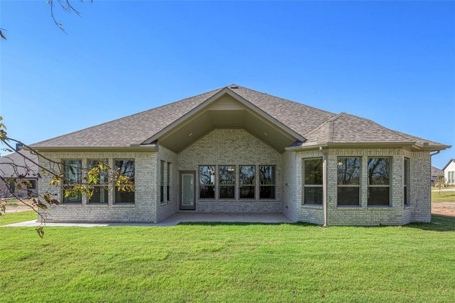 Rear view of property featuring a patio, a lawn, and brick siding Rear view of property featuring a patio, a lawn, and brick siding