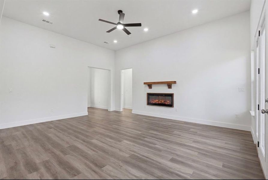Spacious living area featuring high vaulted ceilings, recessed lighting, and wood-finish flooring