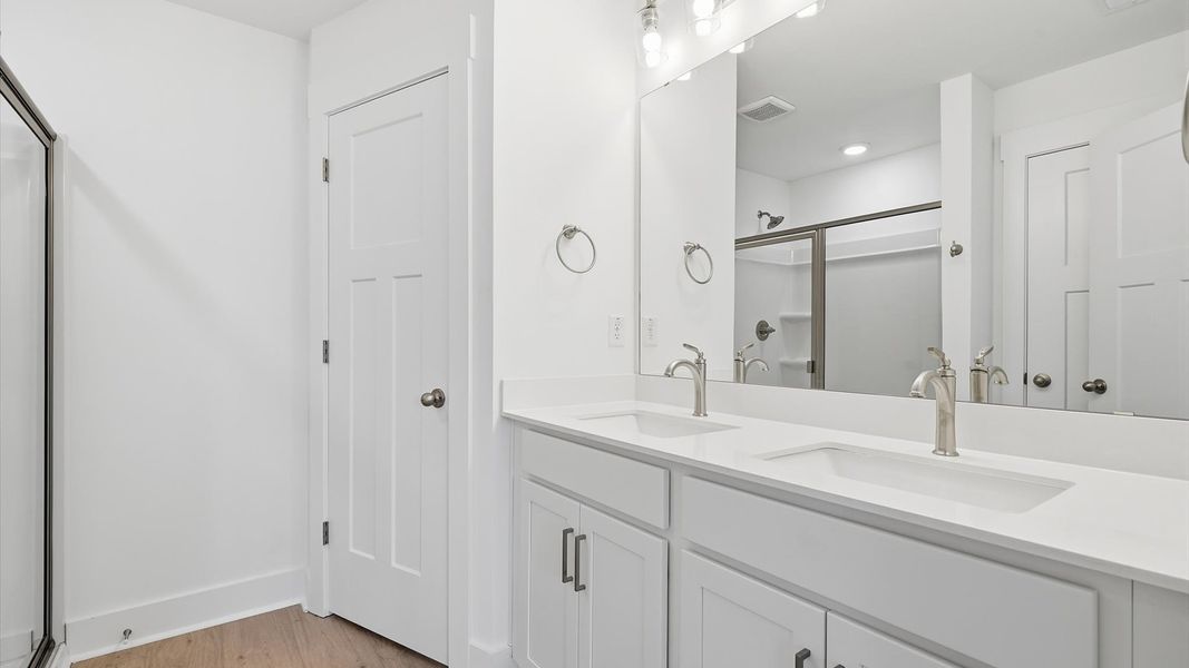 Notable primary suite with dual vanities and walk-in shower in this prime Fountain Inn villa Notable primary suite with dual vanities and walk-in shower in this prime Fountain Inn villa