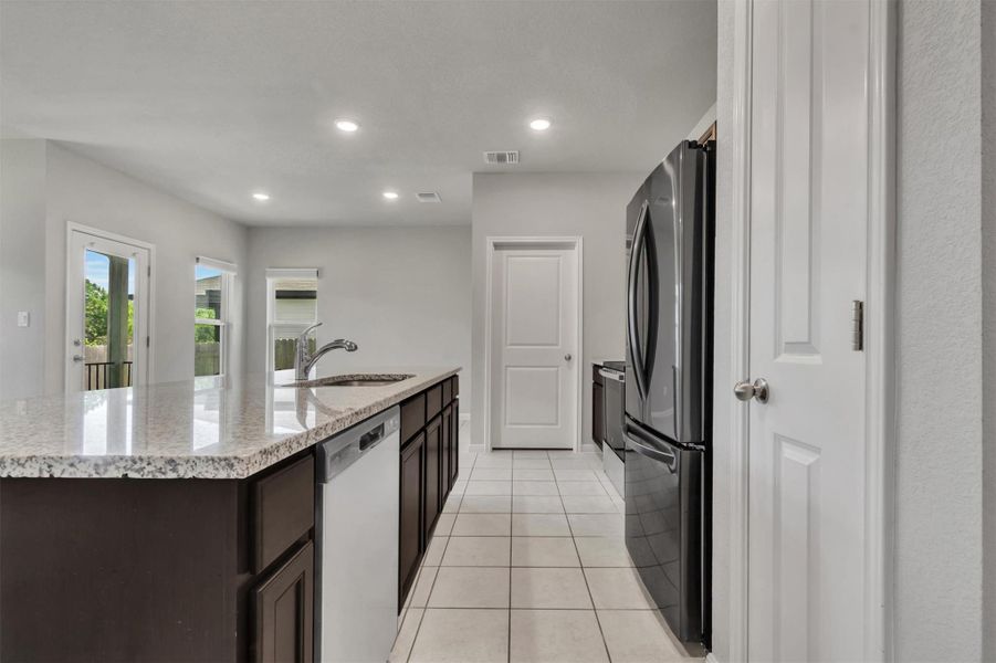 Modern kitchen with granite countertops and stainless steel appliances.