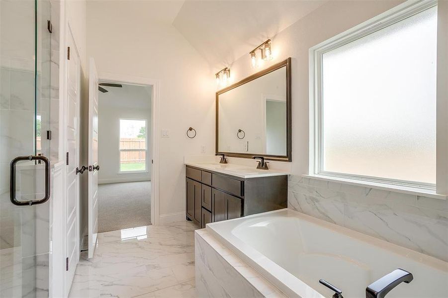 Bathroom featuring lofted ceiling, plus walk in shower, and vanity