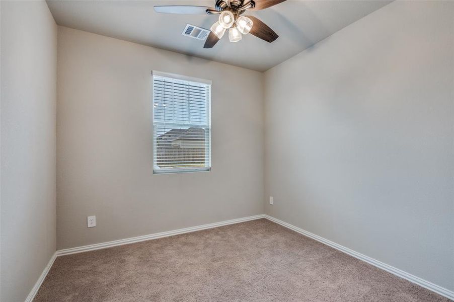 Carpeted empty room featuring baseboards and a ceiling fan