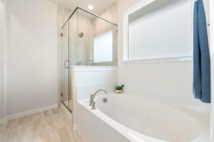 Full bathroom featuring a bath, a stall shower, and recessed lighting