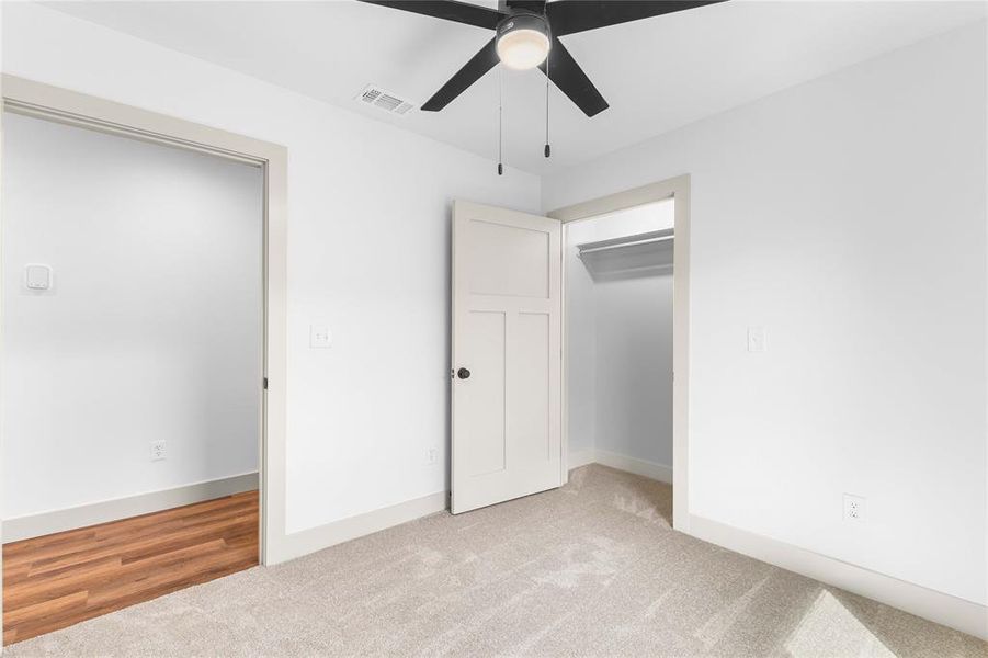 Unfurnished bedroom featuring light colored carpet, a ceiling fan, and a closet Unfurnished bedroom featuring light colored carpet, a ceiling fan, and a closet