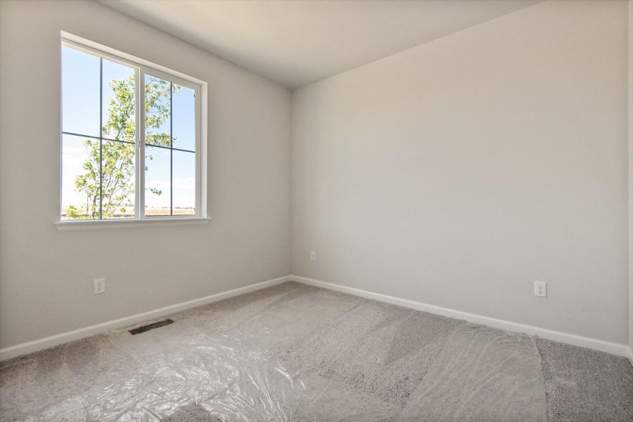 A room with a window and a rug in it.