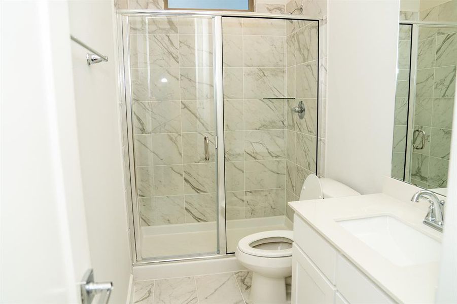 Modern bathroom featuring a glass-enclosed shower with marble-style tile surround, a white vanity with an integrated sink, a large mirror, and polished chrome fixtures Modern bathroom featuring a glass-enclosed shower with marble-style tile surround, a white vanity with an integrated sink, a large mirror, and polished chrome fixtures