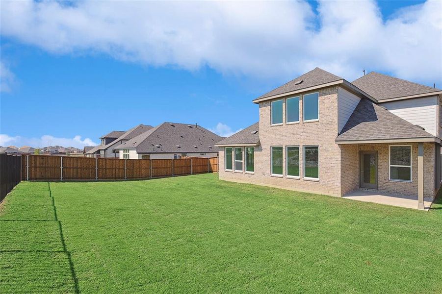 Rear view of house with a yard and a patio area