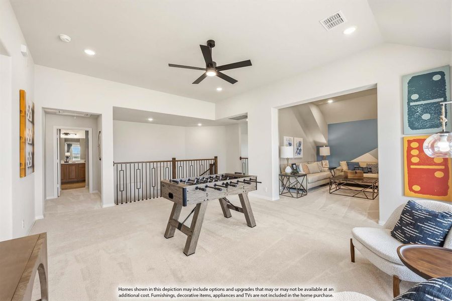 Upstairs game room with foosball table, carpet flooring, ceiling fan, and open staircase railing