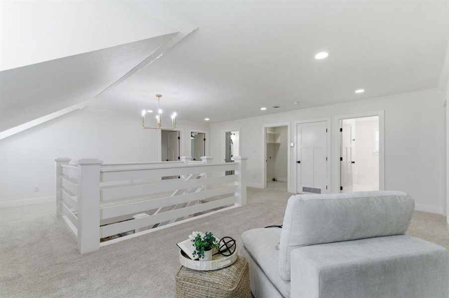 This bright open space features a white railing, soft grey carpeting, and recessed lighting This bright open space features a white railing, soft grey carpeting, and recessed lighting