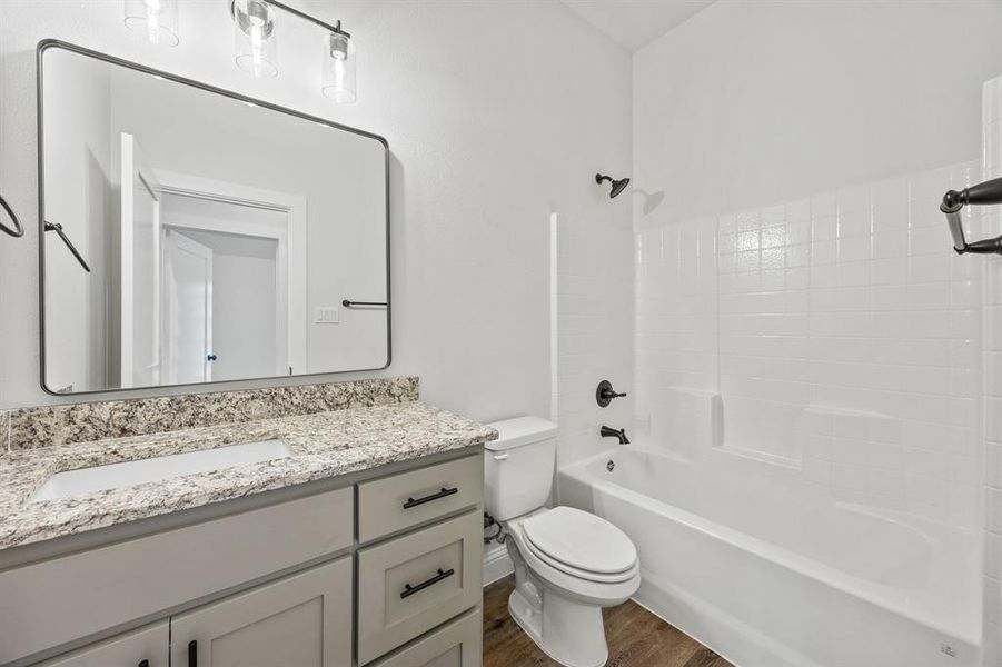 Bathroom featuring bathtub / shower combination, vanity, and dark wood finished floors
