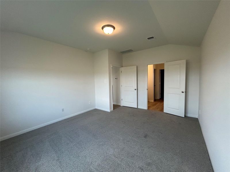 Unfurnished bedroom featuring carpet flooring and vaulted ceiling Unfurnished bedroom featuring carpet flooring and vaulted ceiling