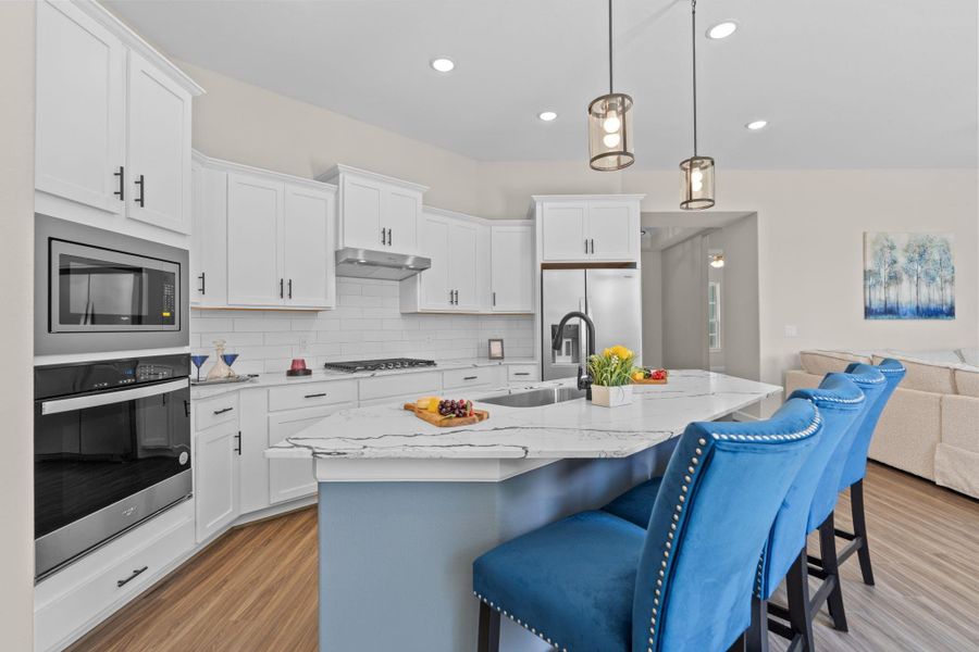 Experience the pinnacle of modern living with the Portico's open floorplan at Winfrey Estates, where the living area, kitchen, and dining area blend seamlessly to create a spacious and inviting environment. This thoughtfully designed layout enhances flow and connectivity, offering the perfect backdrop for entertaining and everyday life in a setting that exudes elegance and comfort. *Image depicts similar floorplan in the community.