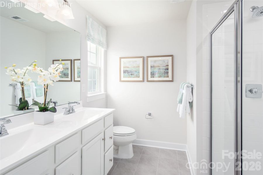 Luxury lives here — with sleek shower doors, dual sinks, and windows that bring in natural light.