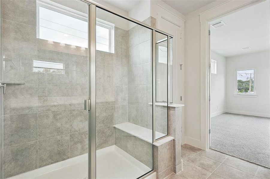 Bathroom with tile patterned flooring and a shower with door