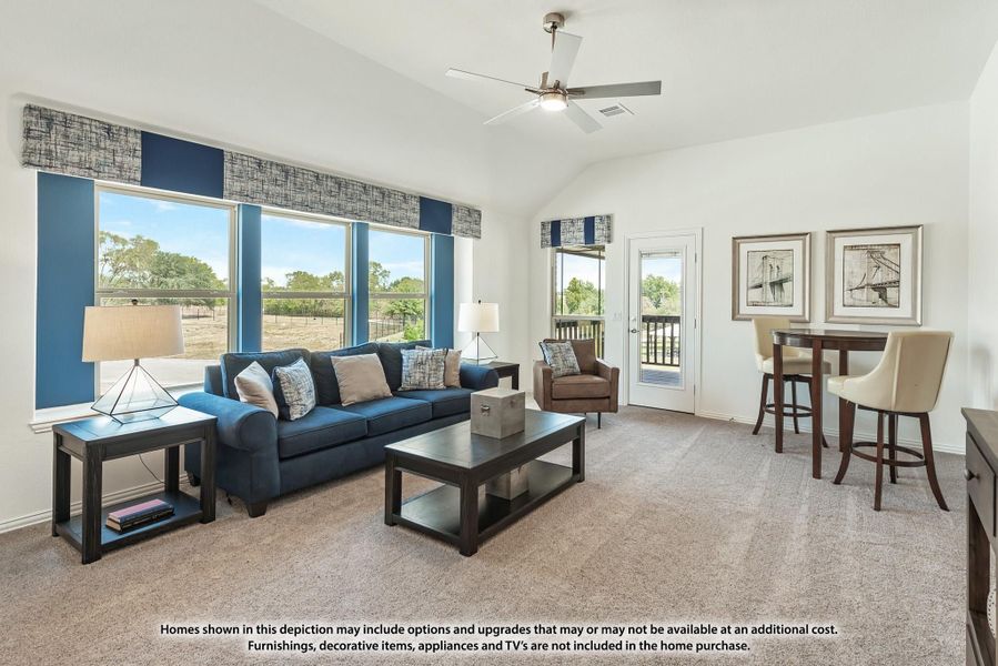 Living room with vaulted ceiling, ceiling fan, blue sofa, carpet flooring, and large windows with backyard views. Living room with vaulted ceiling, ceiling fan, blue sofa, carpet flooring, and large windows with backyard views.