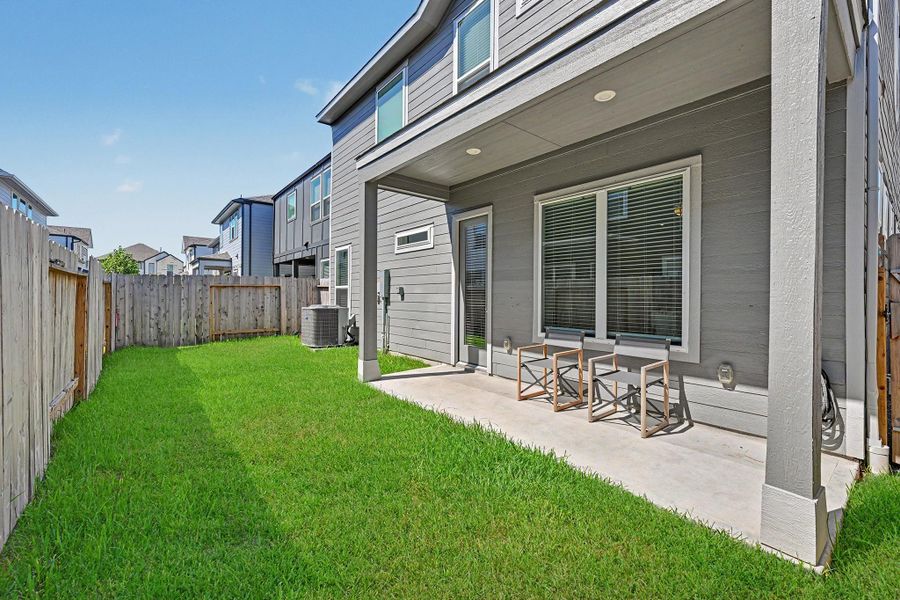 The fenced backyard offers a covered patio with built-in lighting for evenings outdoors. The fenced backyard offers a covered patio with built-in lighting for evenings outdoors.