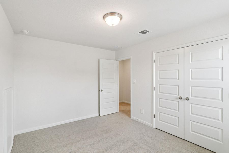 Unfurnished bedroom with light carpet and a closet Unfurnished bedroom with light carpet and a closet