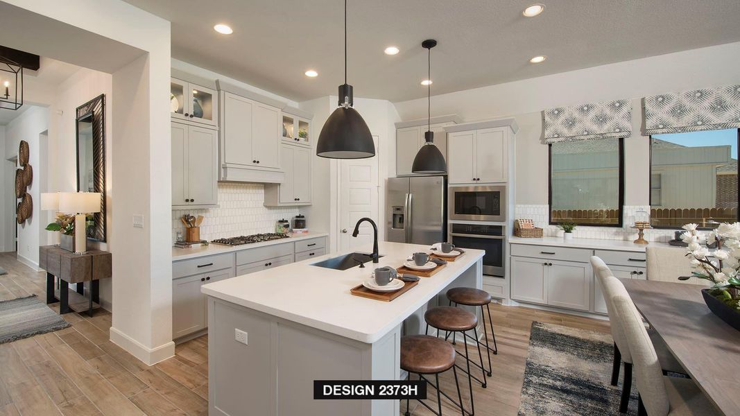 Kitchen featuring light wood-type flooring, a breakfast bar area, decorative backsplash, stainless steel appliances, and recessed lighting Kitchen featuring light wood-type flooring, a breakfast bar area, decorative backsplash, stainless steel appliances, and recessed lighting