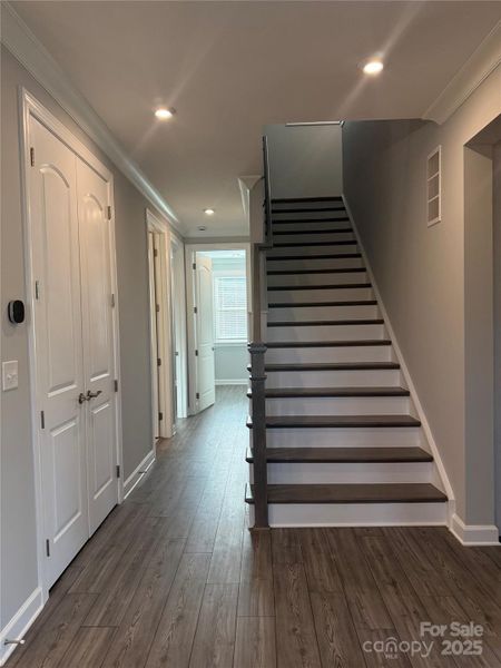 Hall to guest bedrooms on main floor and wood stairs to loft/bedroom