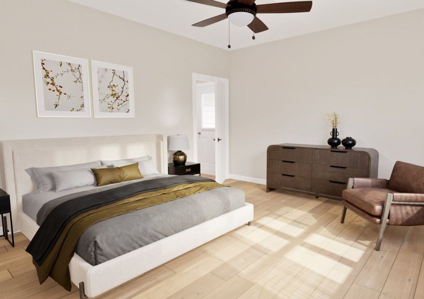 A modern bedroom with a beige palette features a bed with gray and olive bedding, flanked by two nightstands with lamps. A brown chair sits on wooden flooring, and a ceiling fan hangs above, conveying a calm and cozy ambiance.