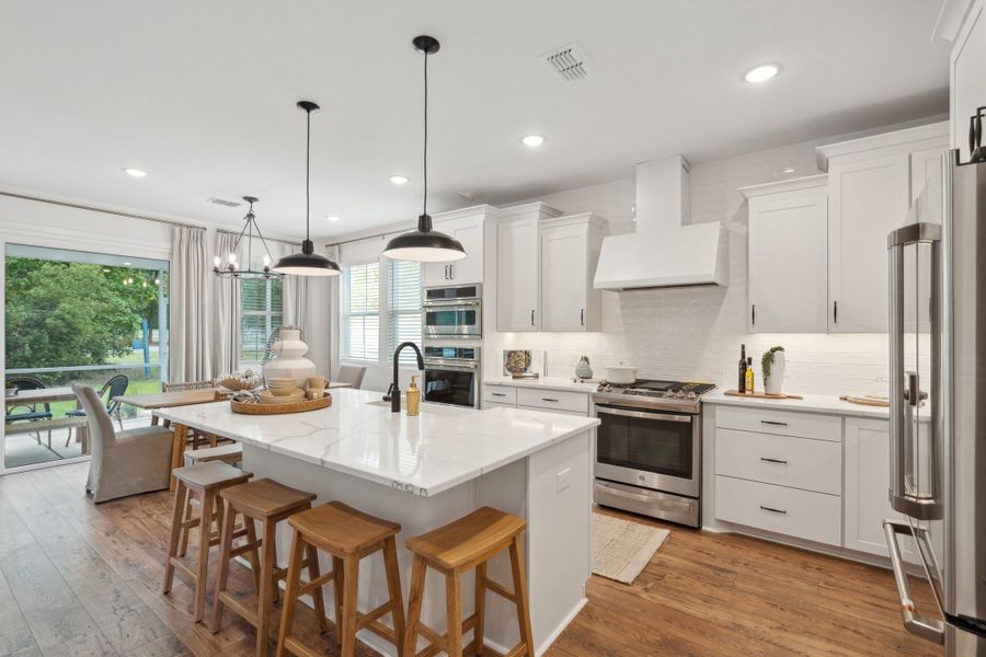 Kitchen with white cabinetry & quartz countertop
