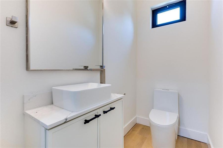 Bathroom featuring vanity, wood-type flooring, and toilet