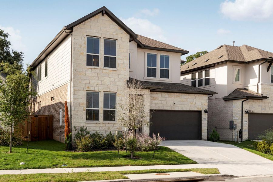 Modern stone and siding home with an attached garage, offering both style and practicality.